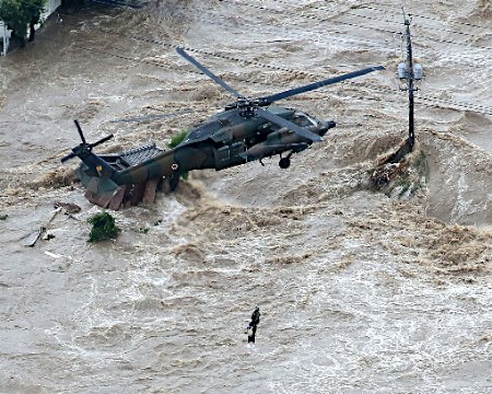 Morador levado pela correnteza é salvo de helicóptero. Foto: Jiji Press